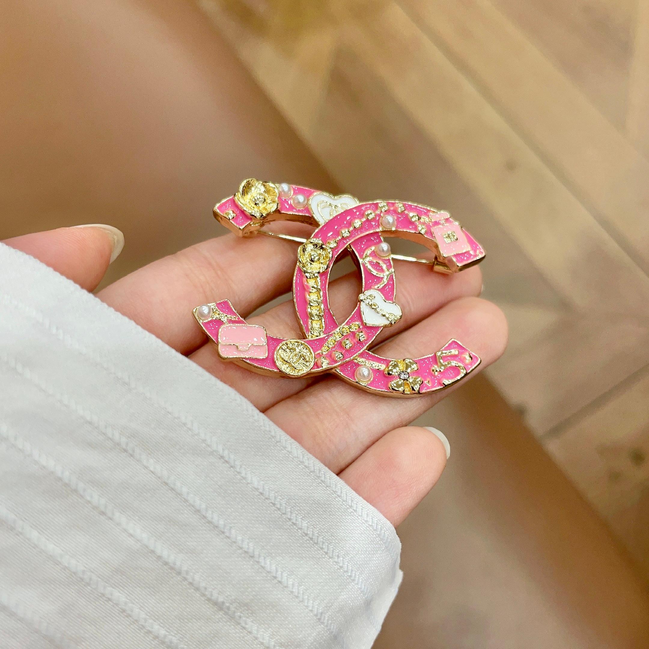 Chanel CC Logo Charms Brooch brooch Gold-tone metal with hot pink enamel white enamel accents white faux pearls 4cm width