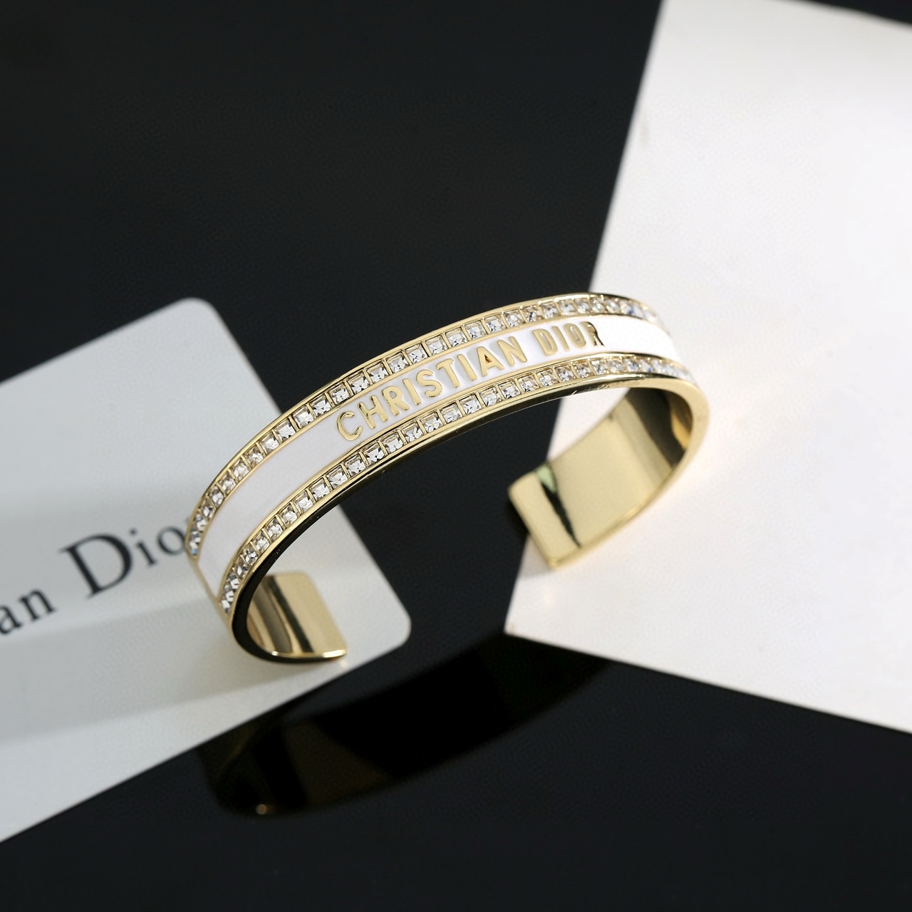 Dior Christian Dior CD Signature Enamel Crystal Cuff bracelet Gold-tone metal with clear crystals available in black enamel or white enamel variants One Size open cuff standard 17cm inner circumference