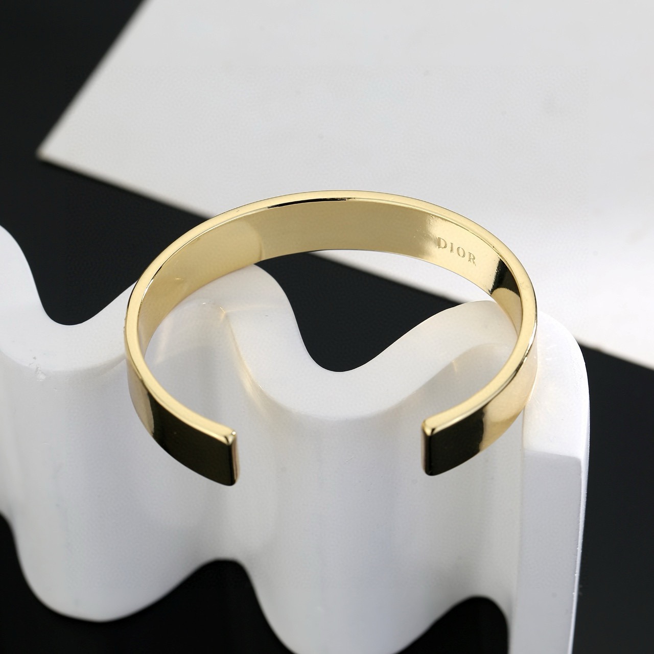 Dior Christian Dior Night Code Cuff bracelet Gold-tone metal with clear crystal accents available with black or white enamel inlay 17cm inner circumference