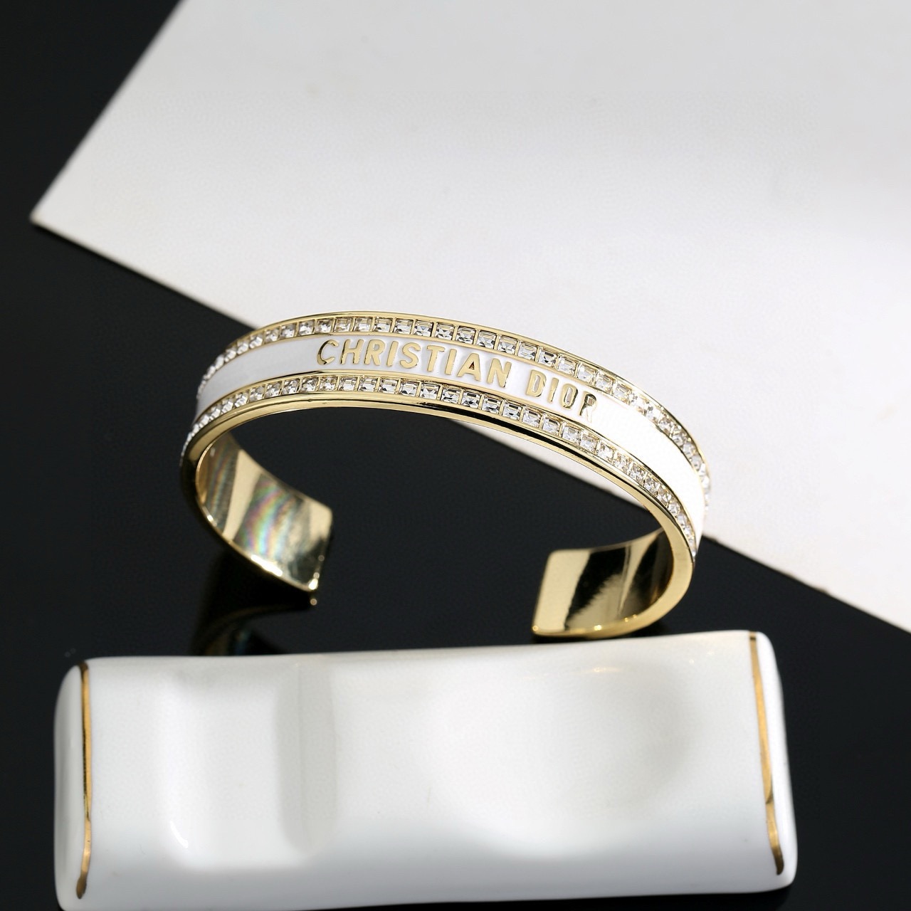 Dior Christian Dior Night Code Cuff bracelet Gold-tone metal with clear crystal accents available with black or white enamel inlay 17cm inner circumference
