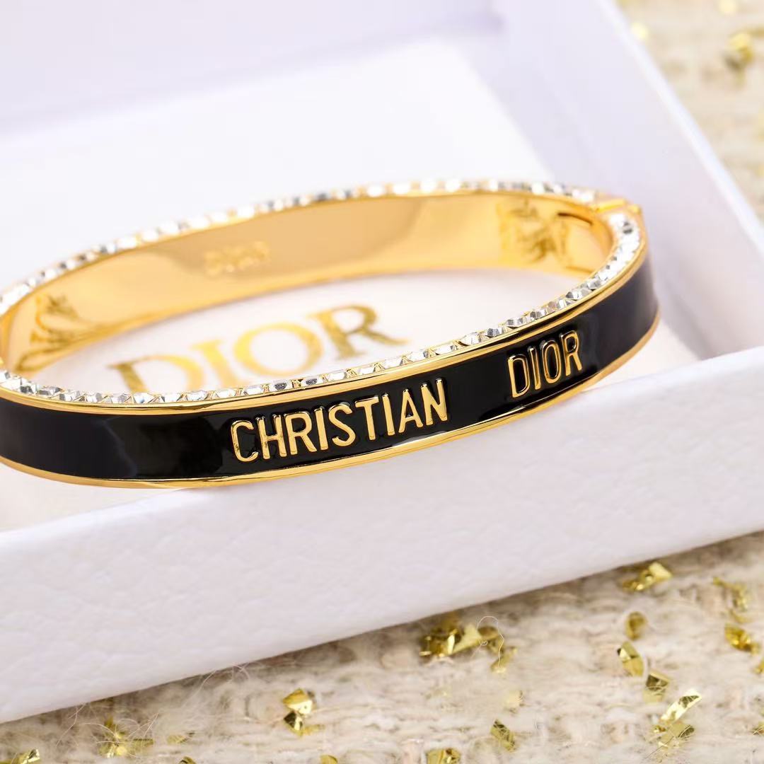 Dior Christian Dior Code Bangle bracelet Gold-tone metal with clear crystal accents available in black enamel and white enamel variants 17cm inner circumference