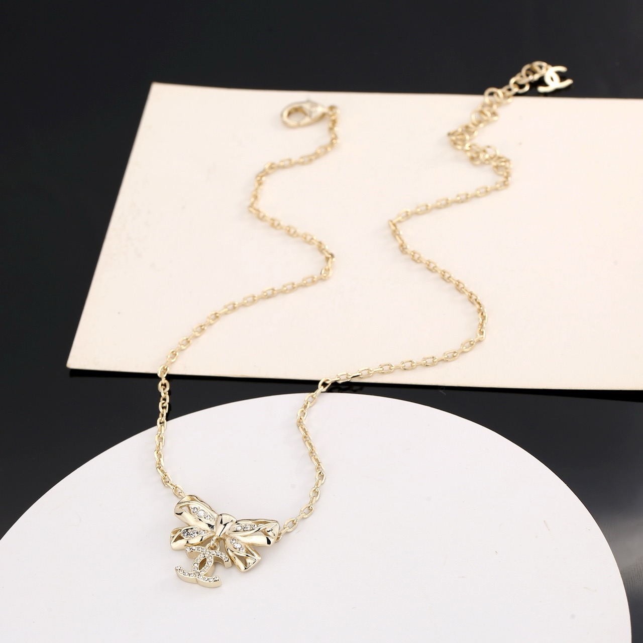 Chanel Crystal Bow CC Pendant Necklace necklace Light gold tone metal with clear crystal accents 42cm with 5cm extender