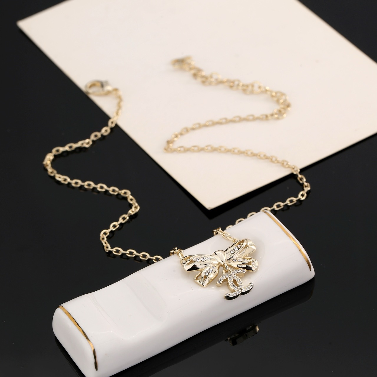 Chanel Crystal Bow CC Pendant Necklace necklace Light gold tone metal with clear crystal accents 42cm with 5cm extender