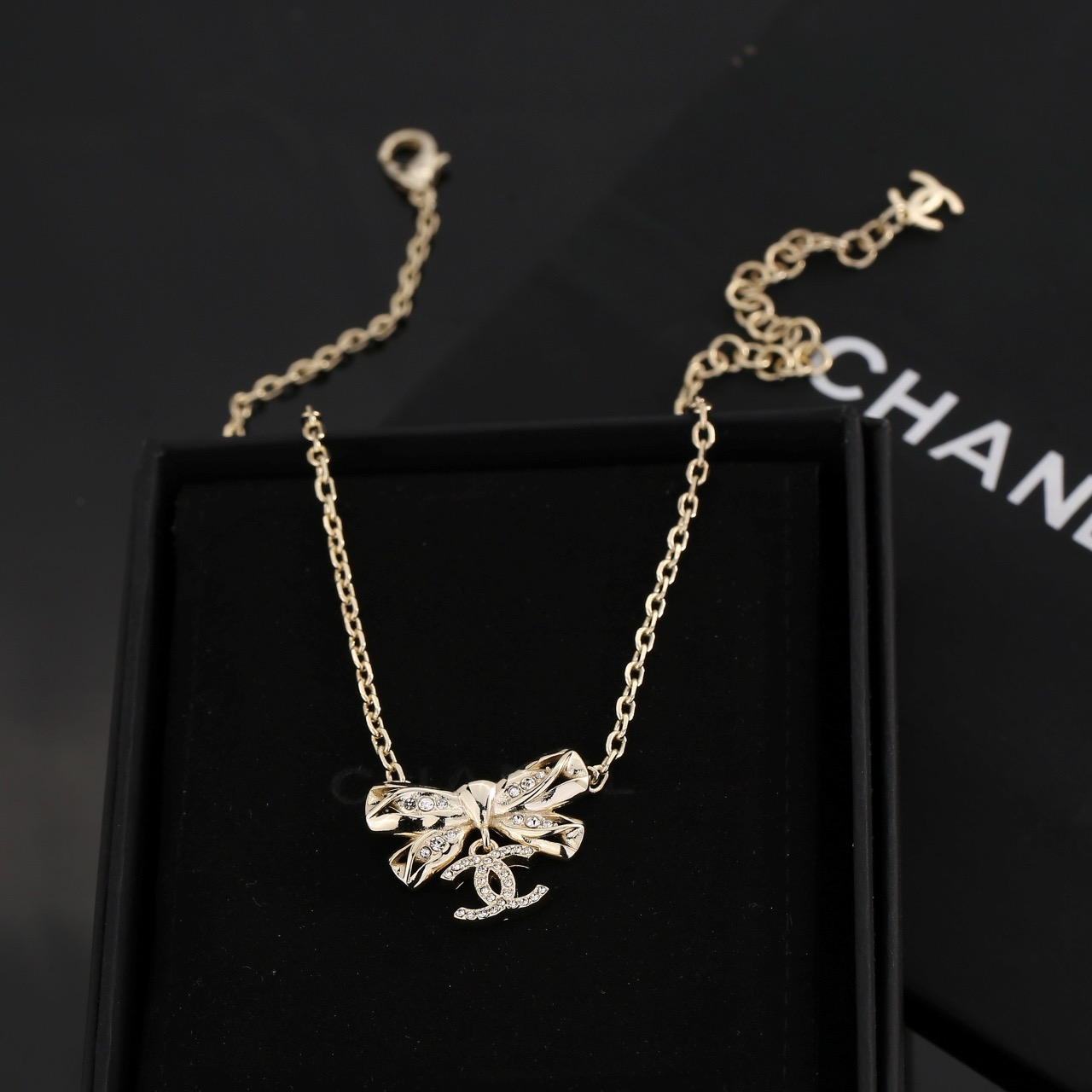 Chanel Crystal Bow CC Pendant Necklace necklace Light gold tone metal with clear crystal accents 42cm with 5cm extender