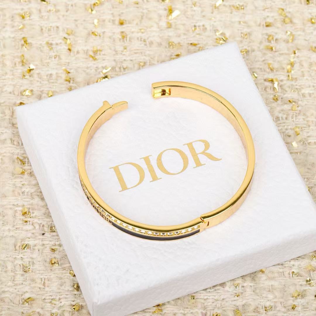 Dior CD New Night Code Bangle bracelet Gold-tone metal with clear channel-set crystals available with white or black enamel accent M