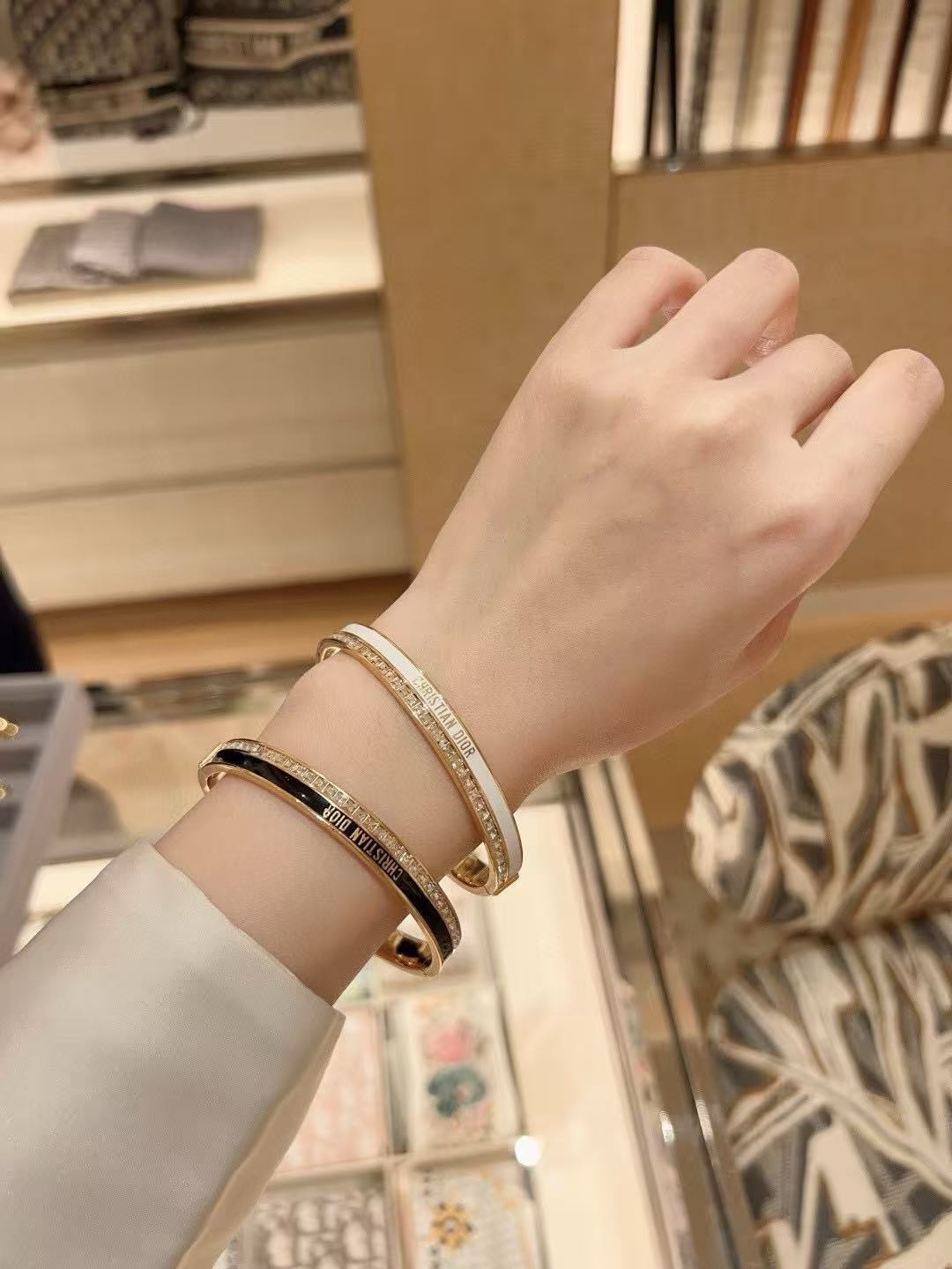Dior CD New Christian Dior Signature Bangle bracelet Gold-tone metal with clear channel-set crystals available with white or black enamel accent M 6 5cm inner diameter
