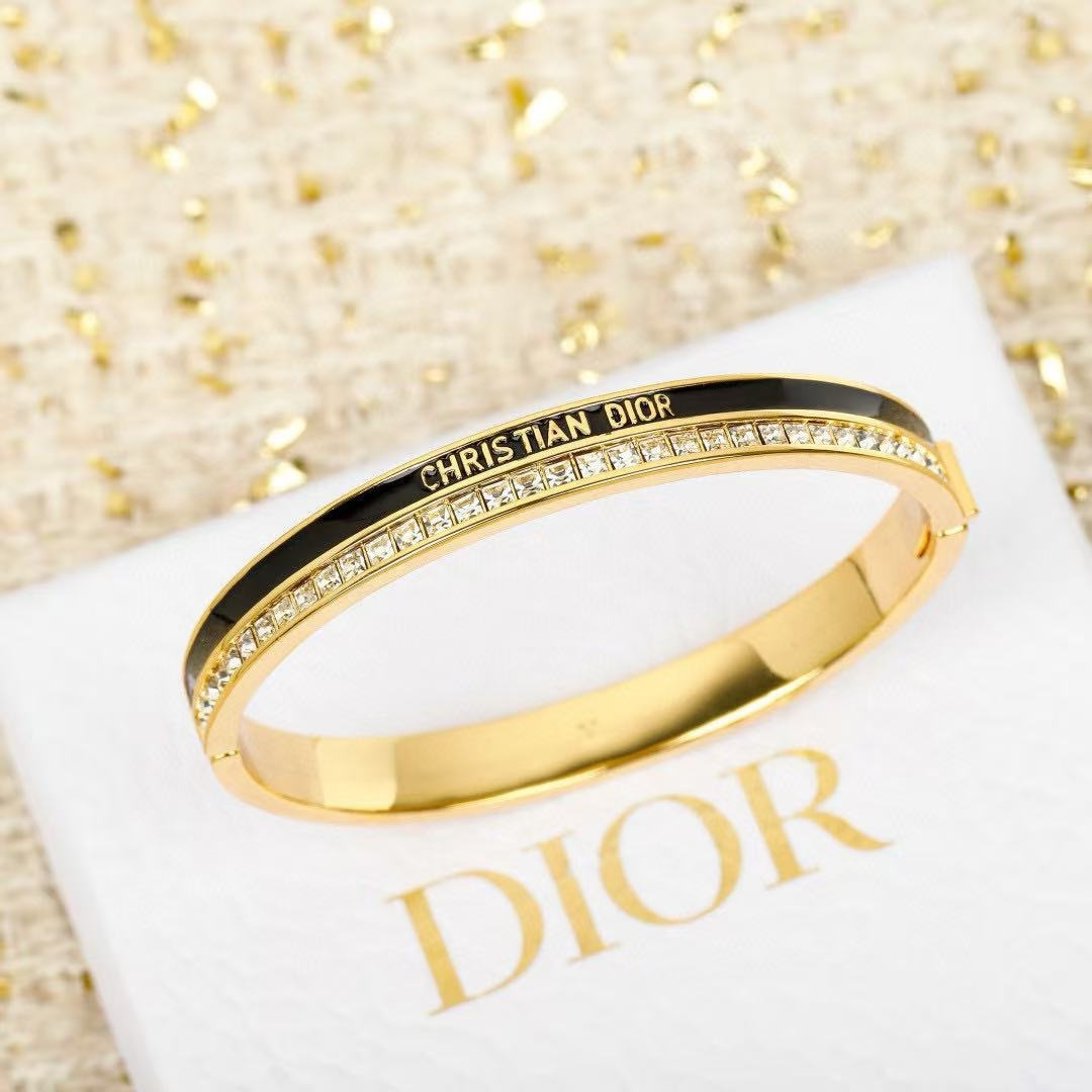 Dior CD New Christian Dior Signature Bangle bracelet Gold-tone metal with clear channel-set crystals available with white or black enamel accent M 6 5cm inner diameter