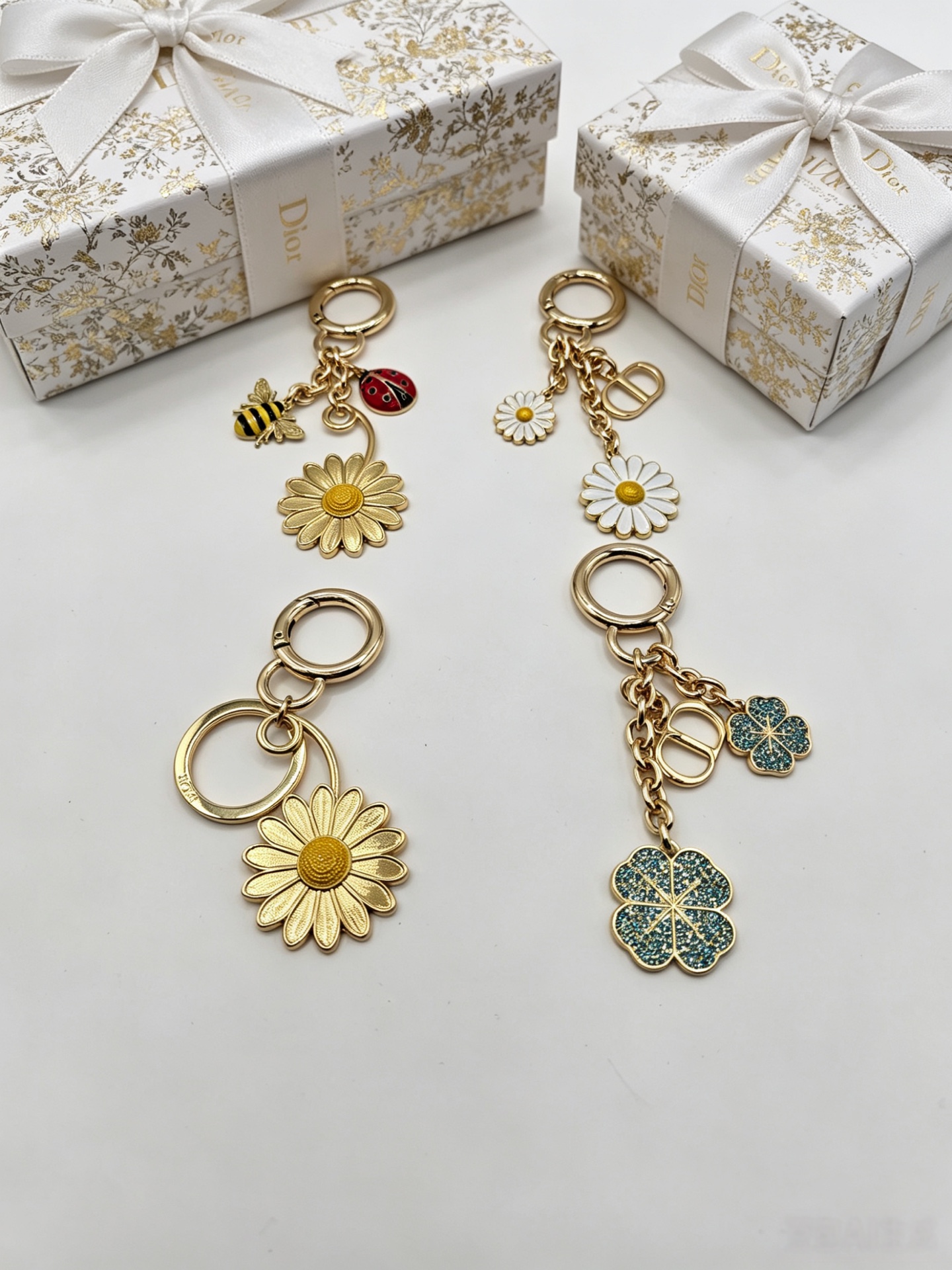 Dior Dior Garden Charms Key Holder pendant Gold-tone metal with yellow and black enamel bee red and black enamel ladybug gold daisy white enamel daisy with yellow center blue glitter four-leaf clover accents Total length 9cm key ring diameter 2 5cm