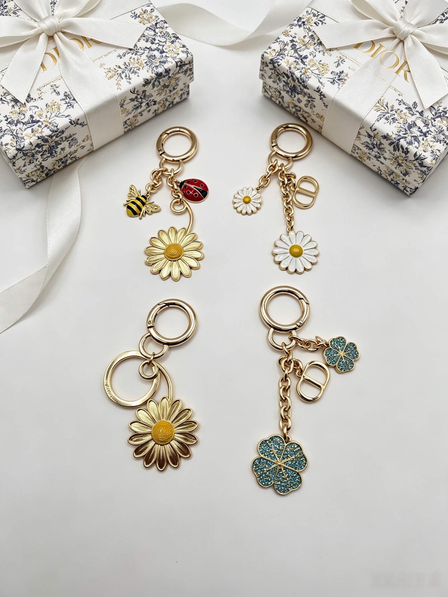 Dior Dior Garden Charms Key Holder pendant Gold-tone metal with yellow and black enamel bee red and black enamel ladybug gold daisy white enamel daisy with yellow center blue glitter four-leaf clover accents Total length 9cm key ring diameter 2 5cm