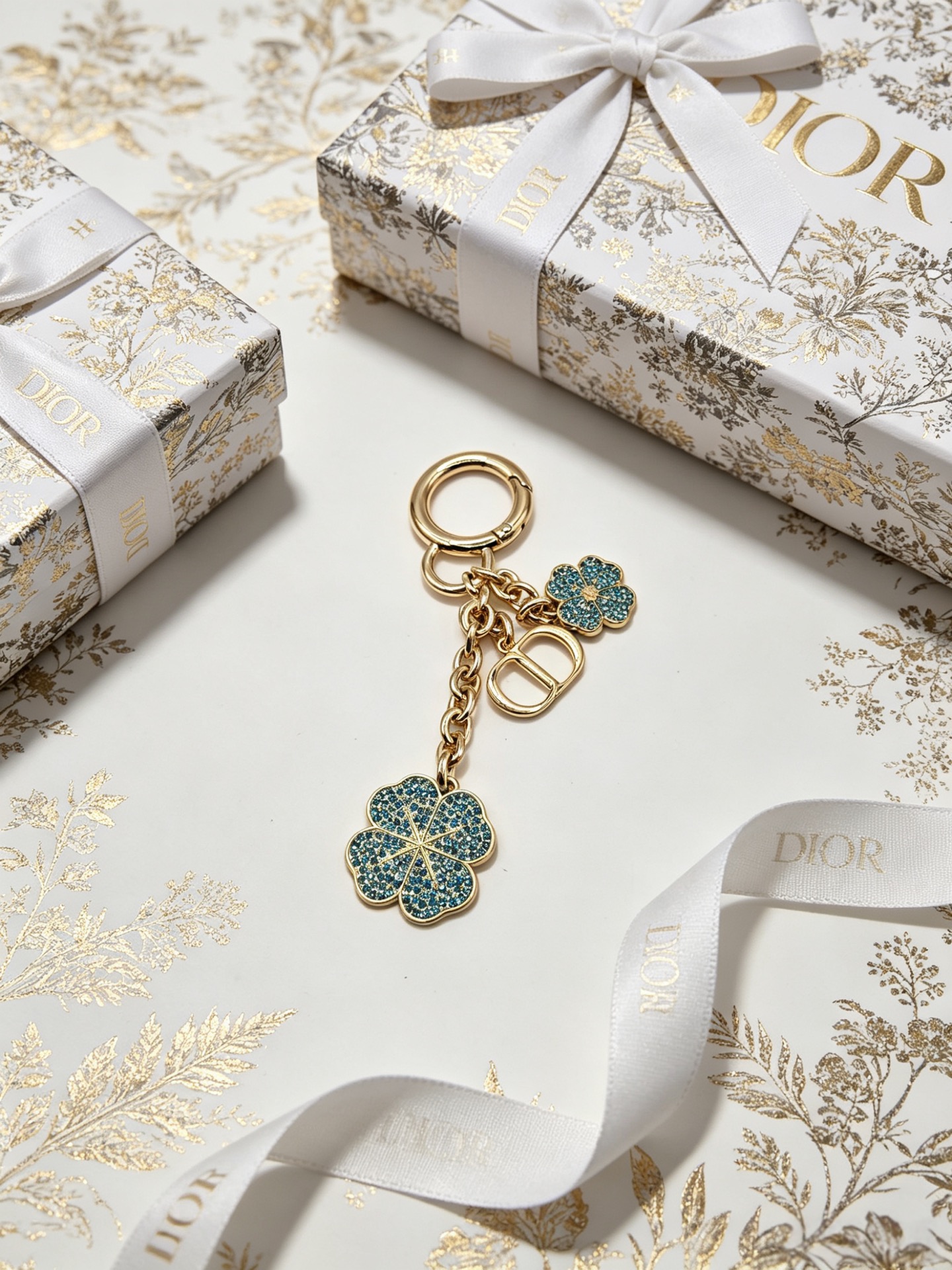 Dior Dior Garden Charms Key Holder pendant Gold-tone metal with yellow and black enamel bee red and black enamel ladybug gold daisy white enamel daisy with yellow center blue glitter four-leaf clover accents Total length 9cm key ring diameter 2 5cm