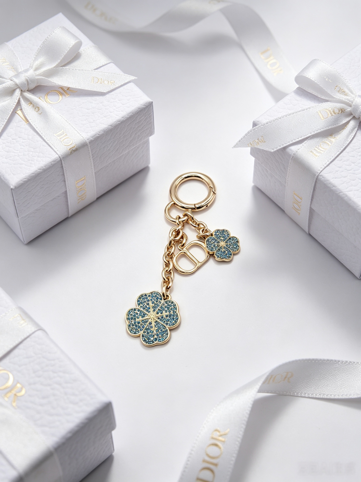 Dior Dior Garden Charms Key Holder pendant Gold-tone metal with yellow and black enamel bee red and black enamel ladybug gold daisy white enamel daisy with yellow center blue glitter four-leaf clover accents Total length 9cm key ring diameter 2 5cm