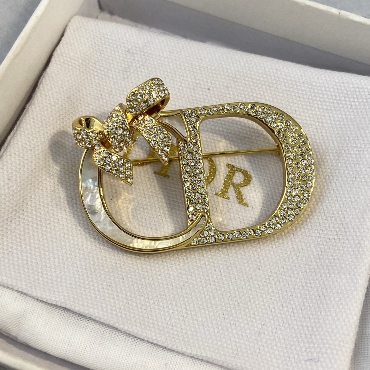 Dior CD Logo Bow Brooch brooch gold-tone metal clear crystal rhinestones white mother-of-pearl inlay 3 5cm width