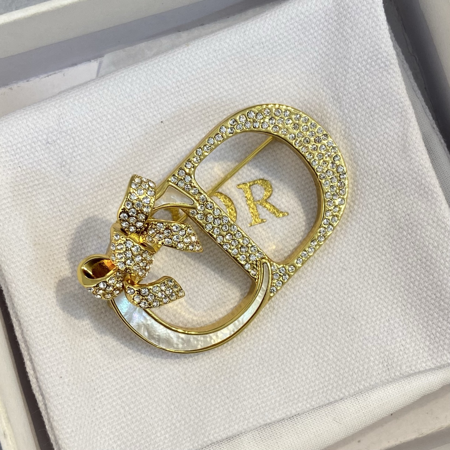 Dior CD Logo Bow Brooch brooch gold-tone metal clear crystal rhinestones white mother-of-pearl inlay 3 5cm width