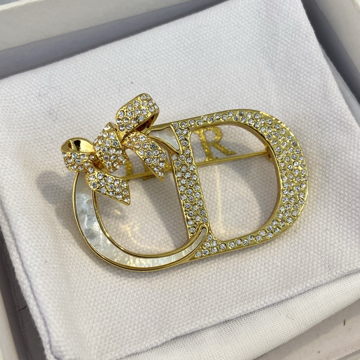 Dior CD Logo Bow Brooch brooch gold-tone metal clear crystal rhinestones white mother-of-pearl inlay 3 5cm width