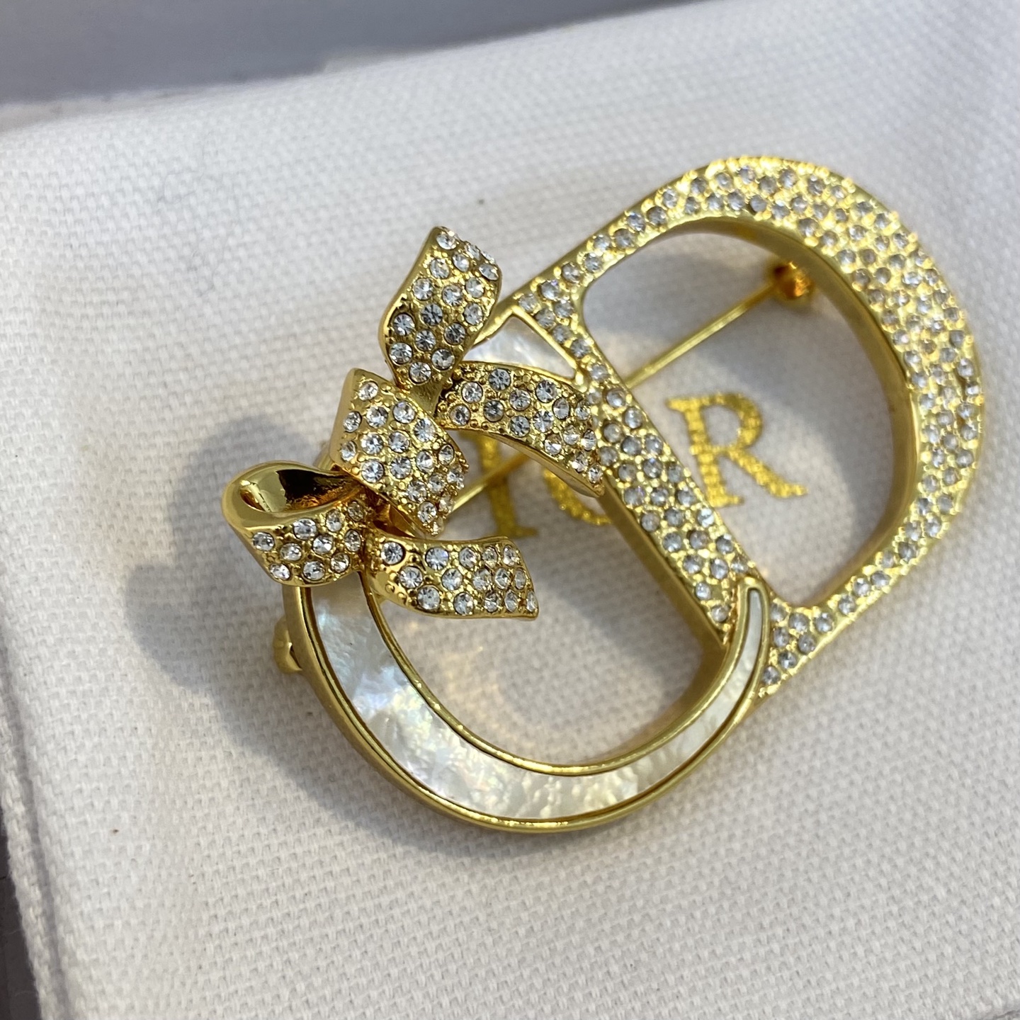 Dior CD Logo Bow Brooch brooch gold-tone metal clear crystal rhinestones white mother-of-pearl inlay 3 5cm width