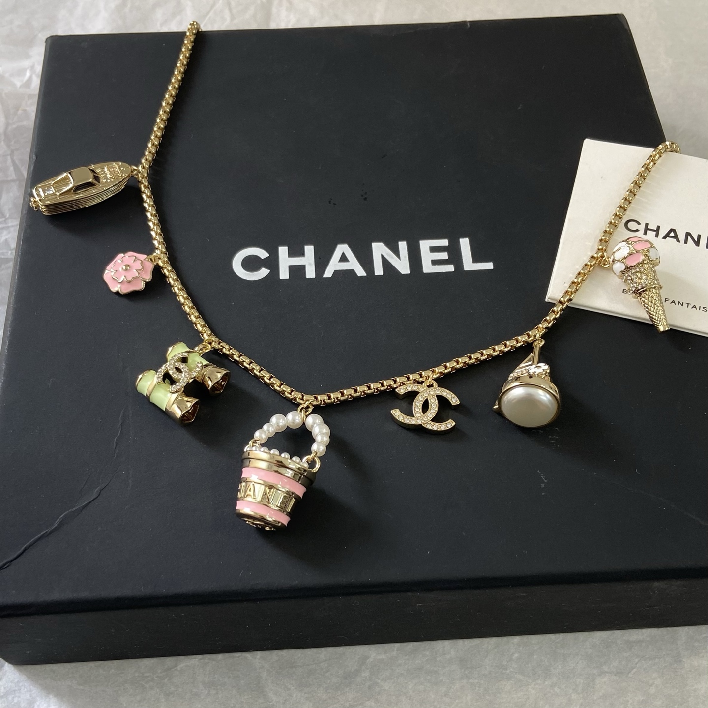 Chanel CC Logo Beach Vacation Charms Collection necklace Gold-tone metal with white faux pearls pink enamel light green enamel clear crystal accents and cream pearl cabochon 42cm with 5cm extender chain