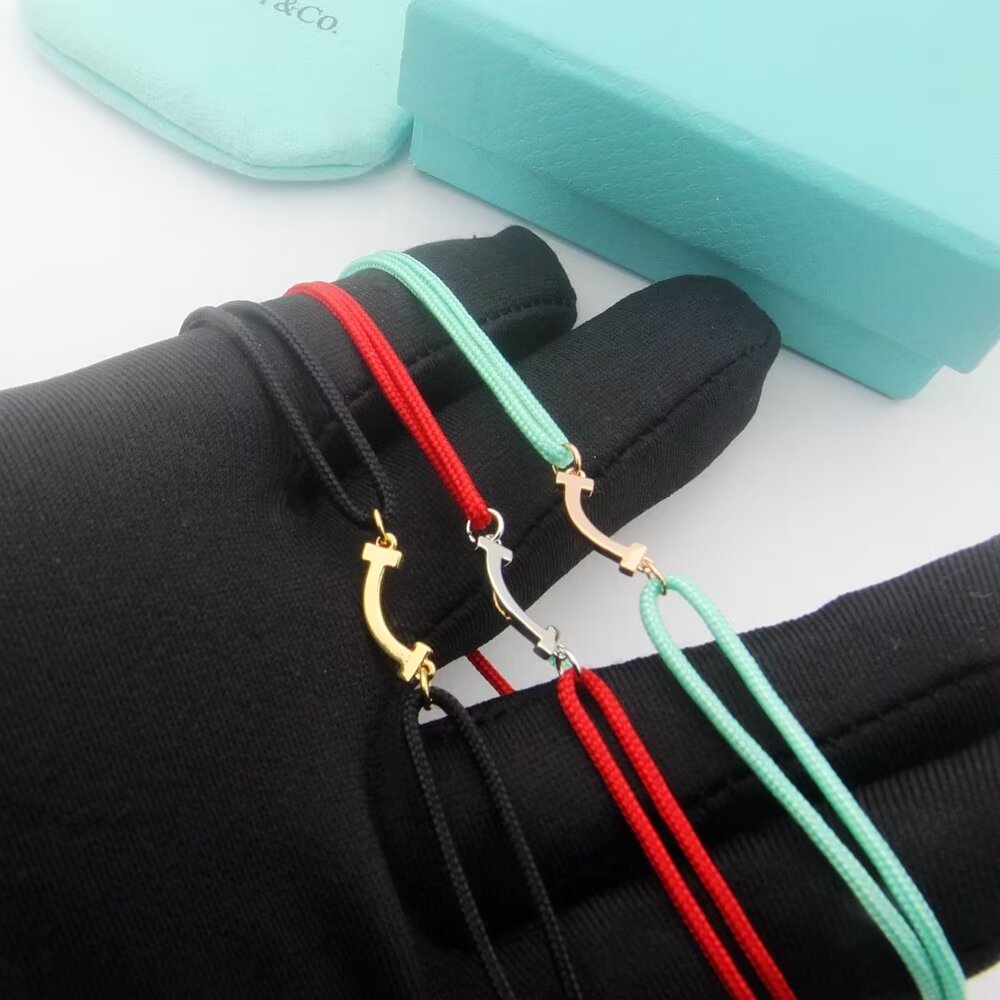 Tiffany Co T Smile bracelet available in yellow gold rose gold silver metal finishes with red black or Tiffany blue cord adjustable sliding knot cord fits 15-20cm wrist