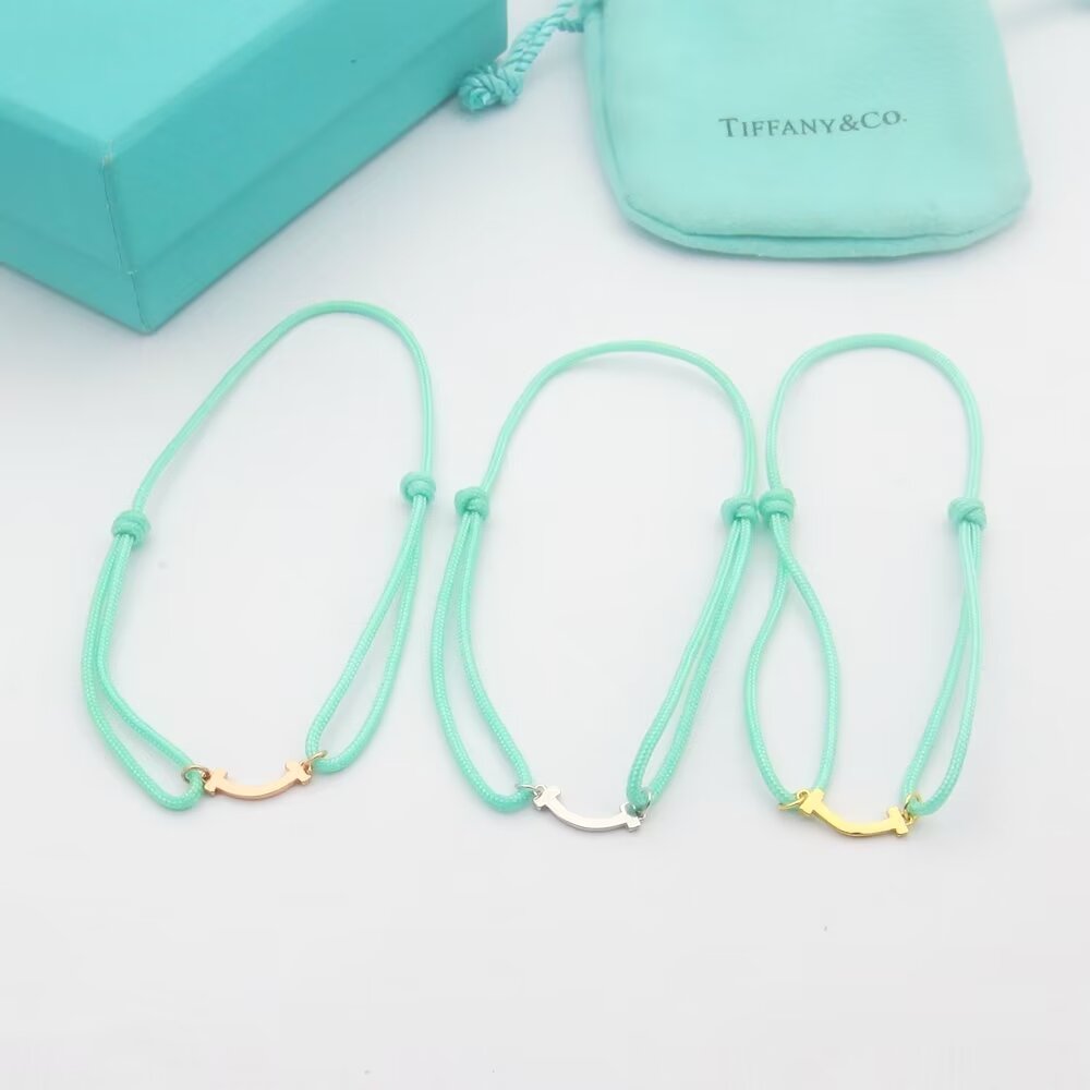 Tiffany Co T Smile bracelet available in yellow gold rose gold silver metal finishes with red black or Tiffany blue cord adjustable sliding knot cord fits 15-20cm wrist