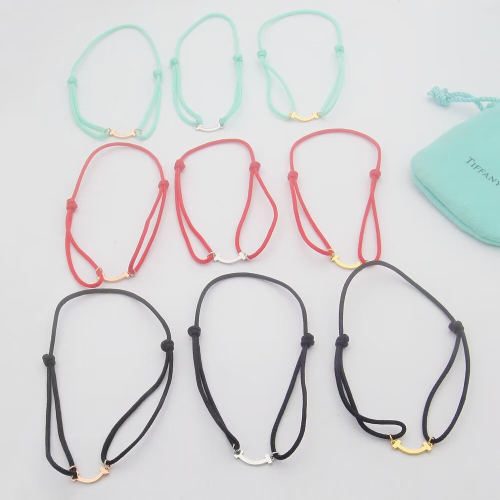 Tiffany Co T Smile bracelet available in yellow gold rose gold silver metal finishes with red black or Tiffany blue cord adjustable sliding knot cord fits 15-20cm wrist