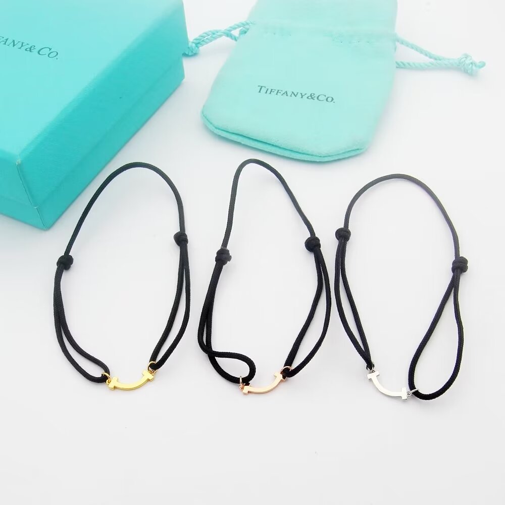 Tiffany Co T Smile bracelet available in yellow gold rose gold silver metal finishes with red black or Tiffany blue cord adjustable sliding knot cord fits 15-20cm wrist