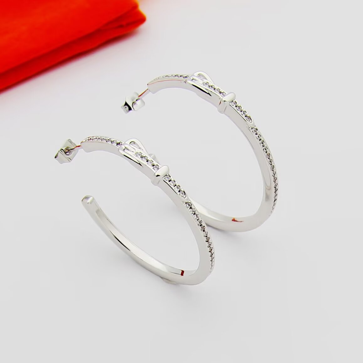 Hermes Buckle Hoop earrings Available in rose gold silver yellow gold metal tones with clear diamond-like accent stones 30mm diameter