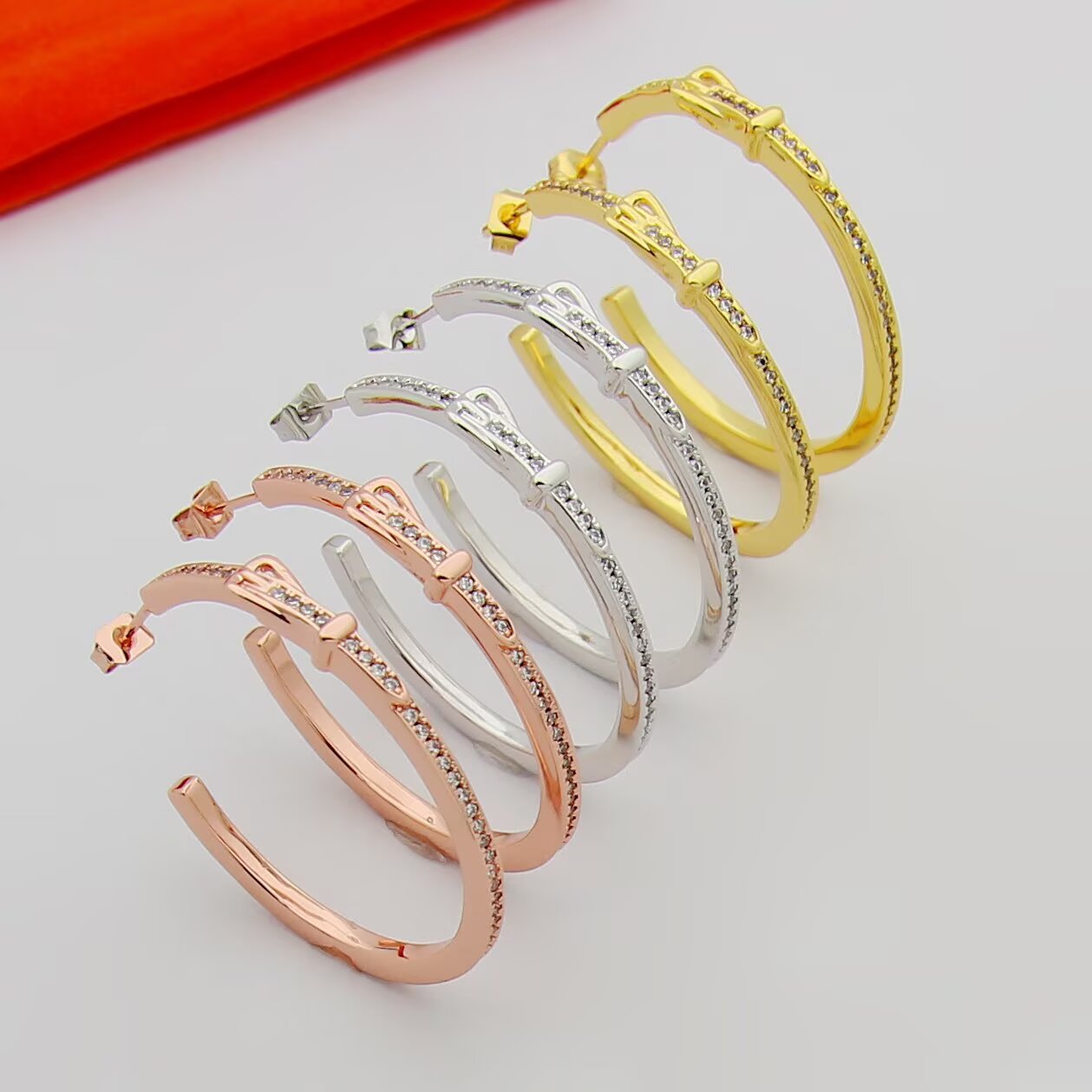 Hermes Buckle Hoop earrings Available in rose gold silver yellow gold metal tones with clear diamond-like accent stones 30mm diameter