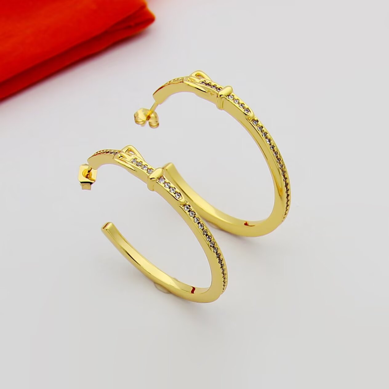 Hermes Buckle Hoop earrings Available in rose gold silver yellow gold metal tones with clear diamond-like accent stones 30mm diameter