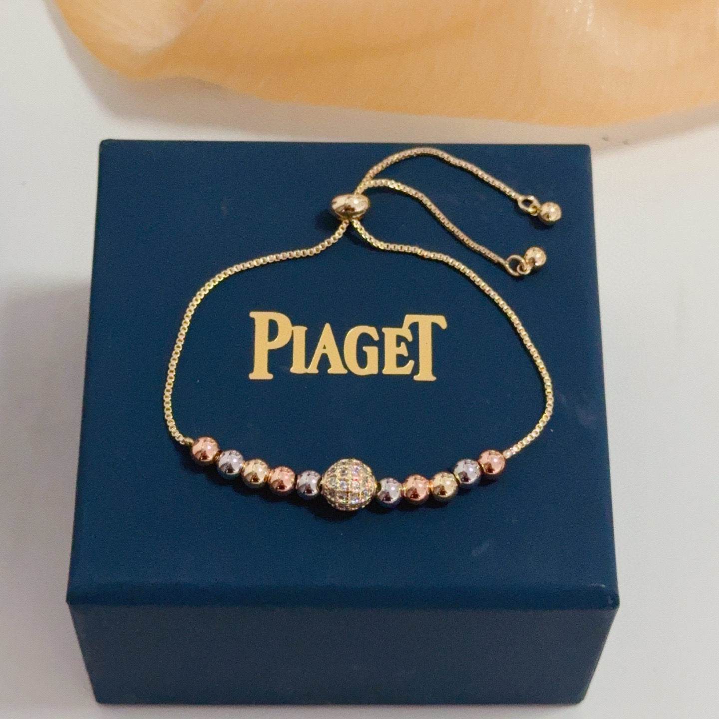 Piaget Possession bracelet tri-tone yellow gold rose gold white gold metal with clear diamond pave accent bead adjustable sliding chain maximum length 22cm