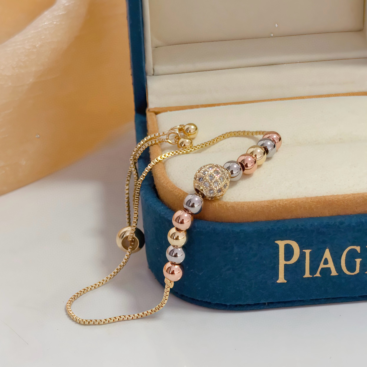 Piaget Possession bracelet tri-tone yellow gold rose gold white gold metal with clear diamond pave accent bead adjustable sliding chain maximum length 22cm