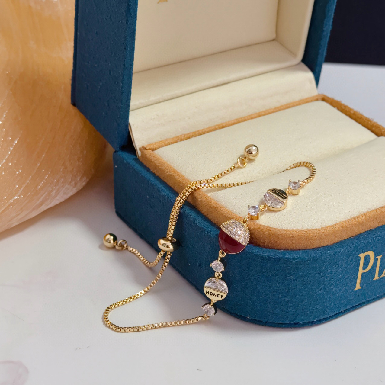 Piaget Possession bracelet yellow gold metal clear diamond-like crystals deep red enamel accent adjustable sliding chain 16-20cm