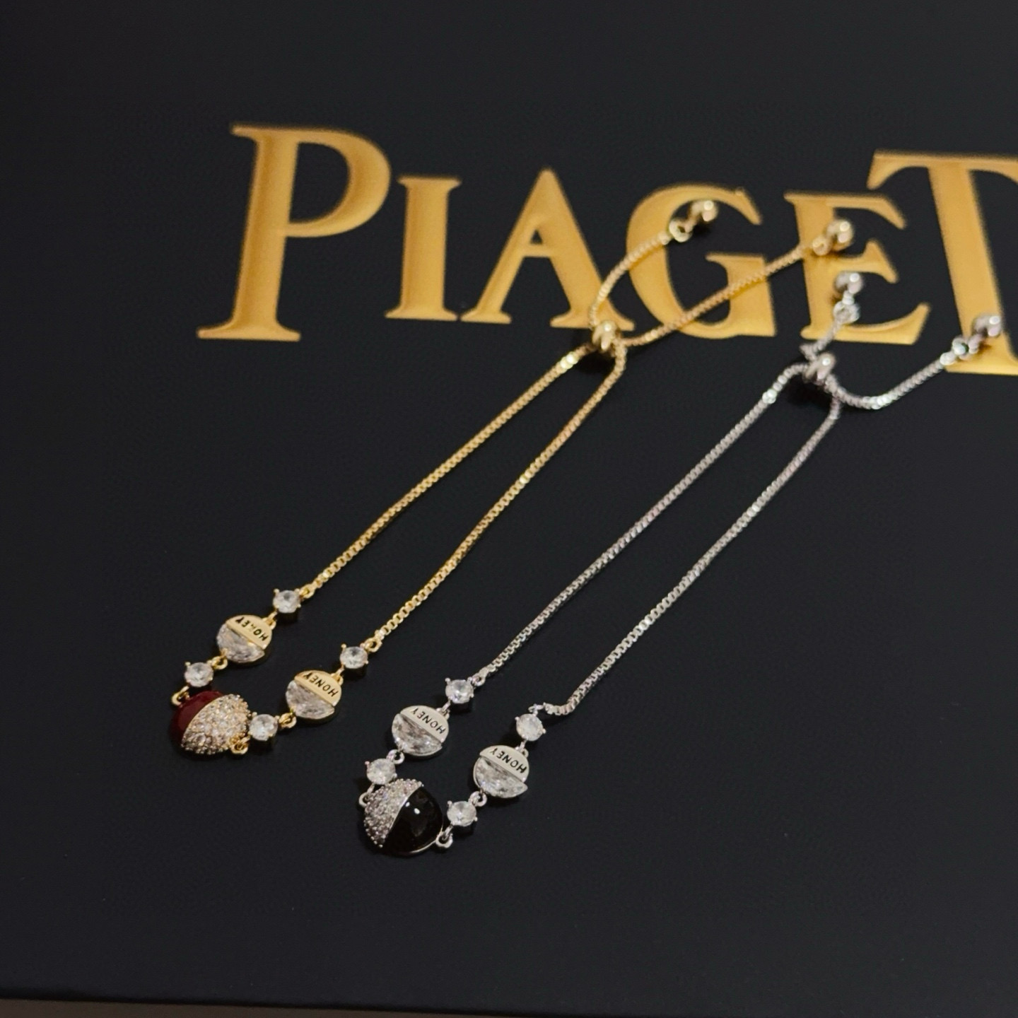 Piaget Possession bracelet yellow gold metal clear diamond-like crystals deep red enamel accent adjustable sliding chain 16-20cm
