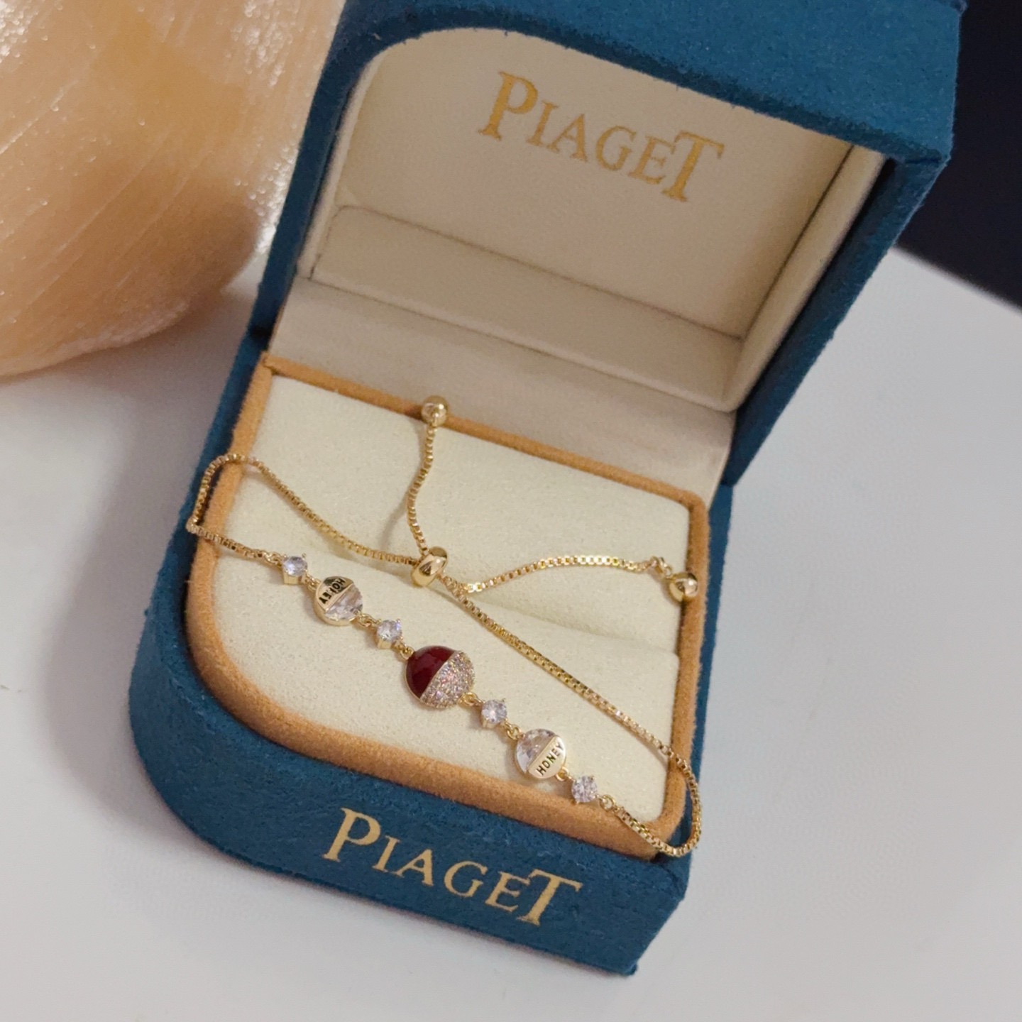 Piaget Possession bracelet yellow gold metal clear diamond-like crystals deep red enamel accent adjustable sliding chain 16-20cm