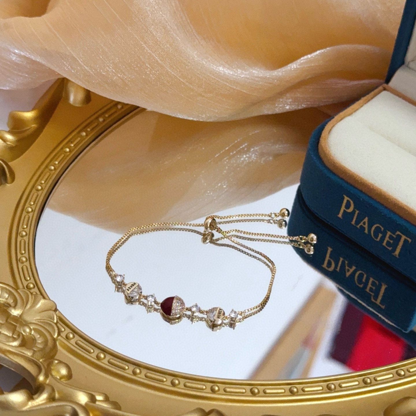 Piaget Possession bracelet yellow gold metal clear diamond-like crystals deep red enamel accent adjustable sliding chain 16-20cm