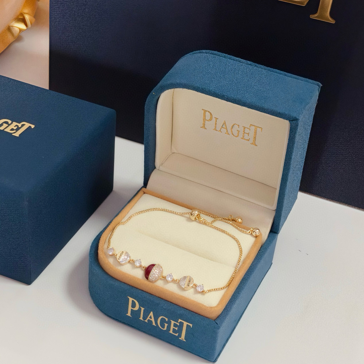 Piaget Possession bracelet yellow gold metal clear diamond-like crystals deep red enamel accent adjustable sliding chain 16-20cm