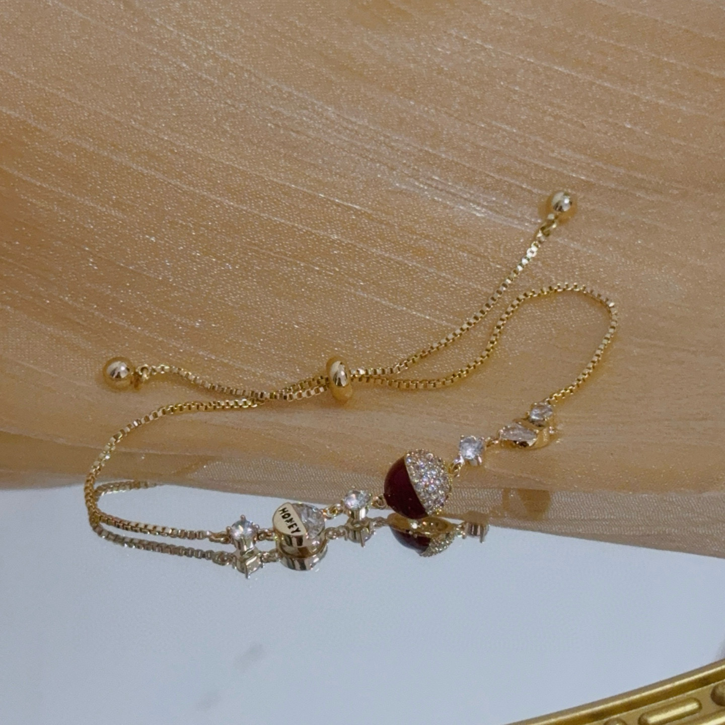 Piaget Possession bracelet yellow gold metal clear diamond-like crystals deep red enamel accent adjustable sliding chain 16-20cm