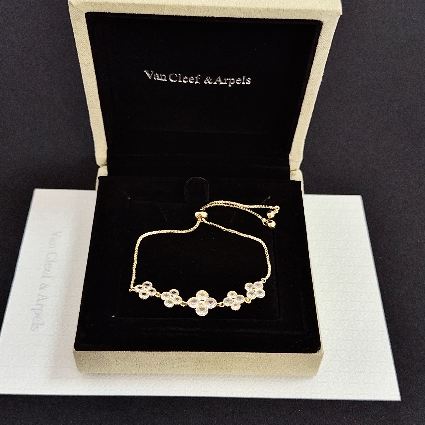Bracciale Van Cleef Arpels Alhambra in metallo color oro con accenti in pietra sfaccettata trasparente, catena scorrevole regolabile, lunghezza massima 22 cm