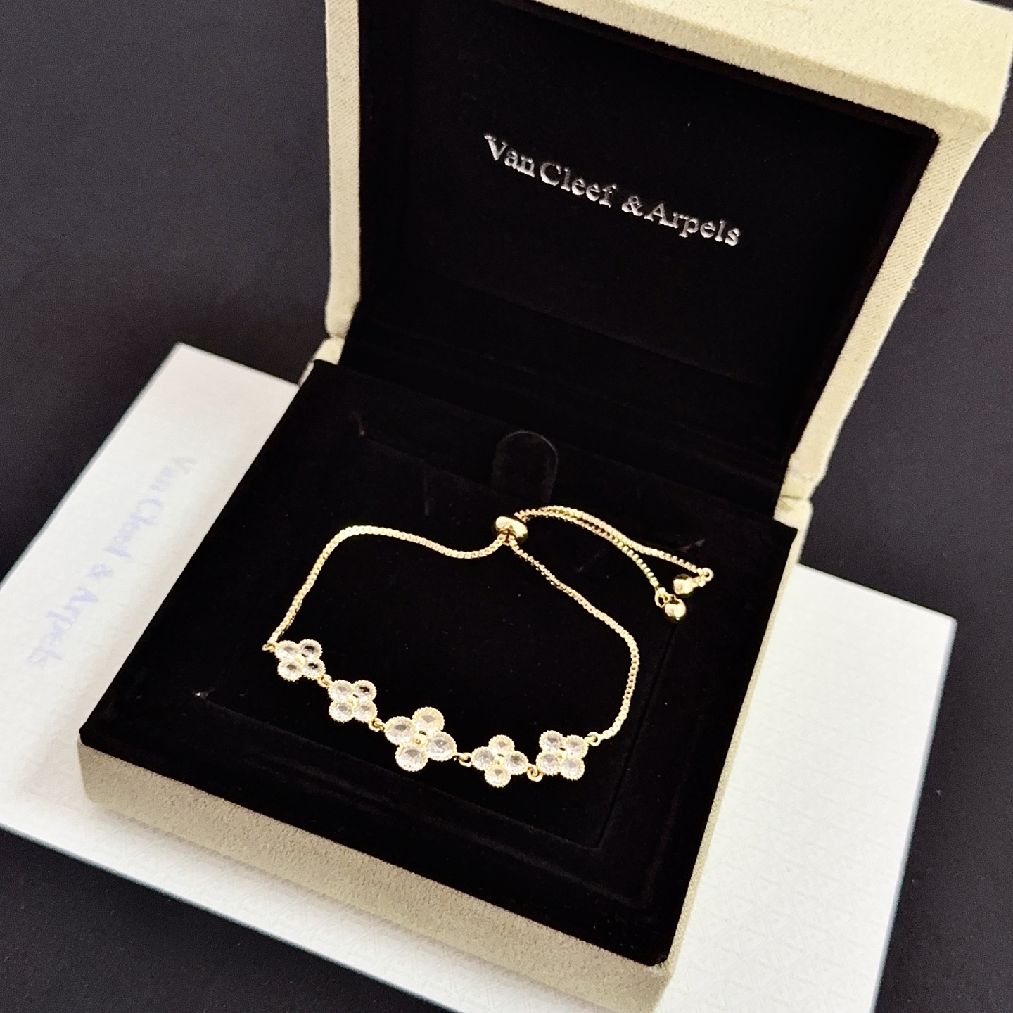 Bracciale Van Cleef Arpels Alhambra in metallo color oro con accenti in pietra sfaccettata trasparente, catena scorrevole regolabile, lunghezza massima 22 cm