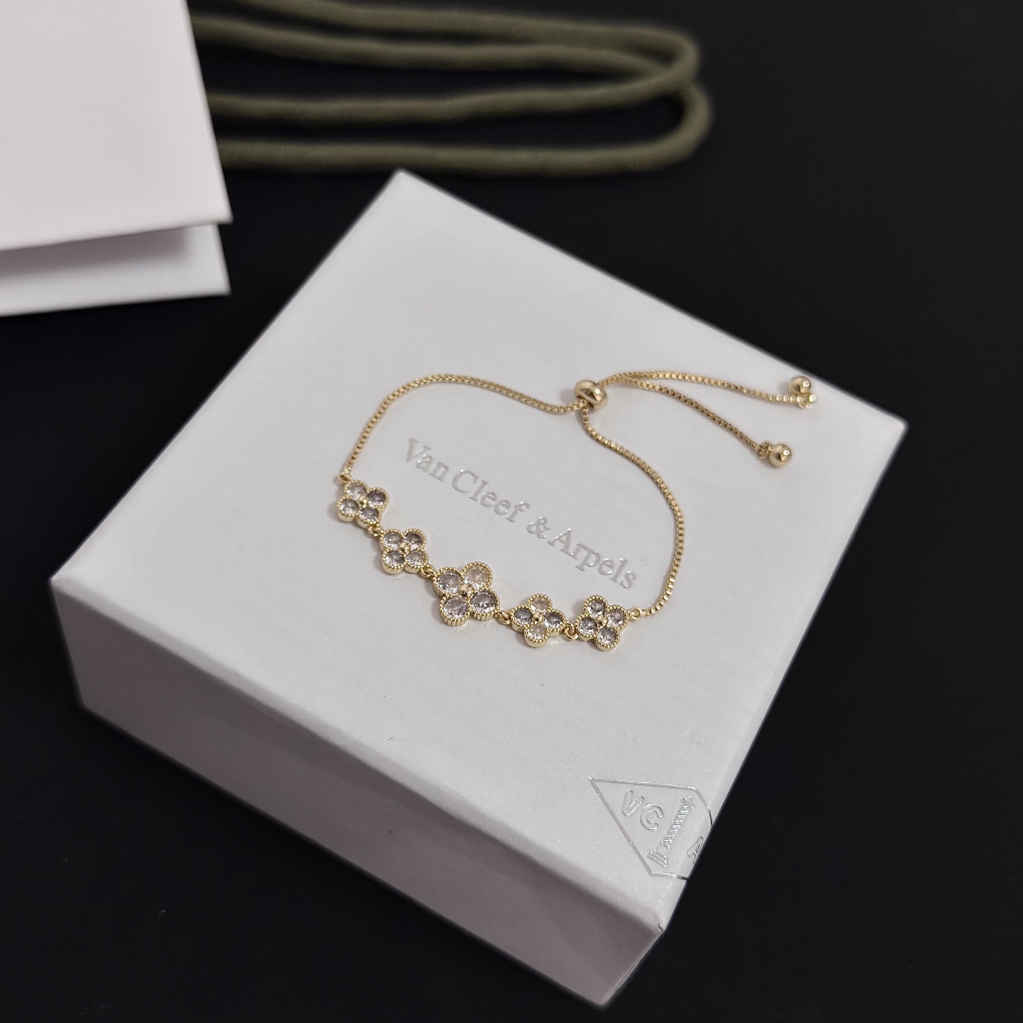 Bracciale Van Cleef Arpels Alhambra in metallo color oro con accenti in pietra sfaccettata trasparente, catena scorrevole regolabile, lunghezza massima 22 cm
