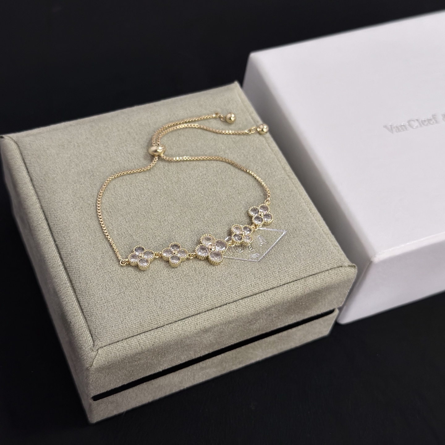 Bracciale Van Cleef Arpels Alhambra in metallo color oro con accenti in pietra sfaccettata trasparente, catena scorrevole regolabile, lunghezza massima 22 cm