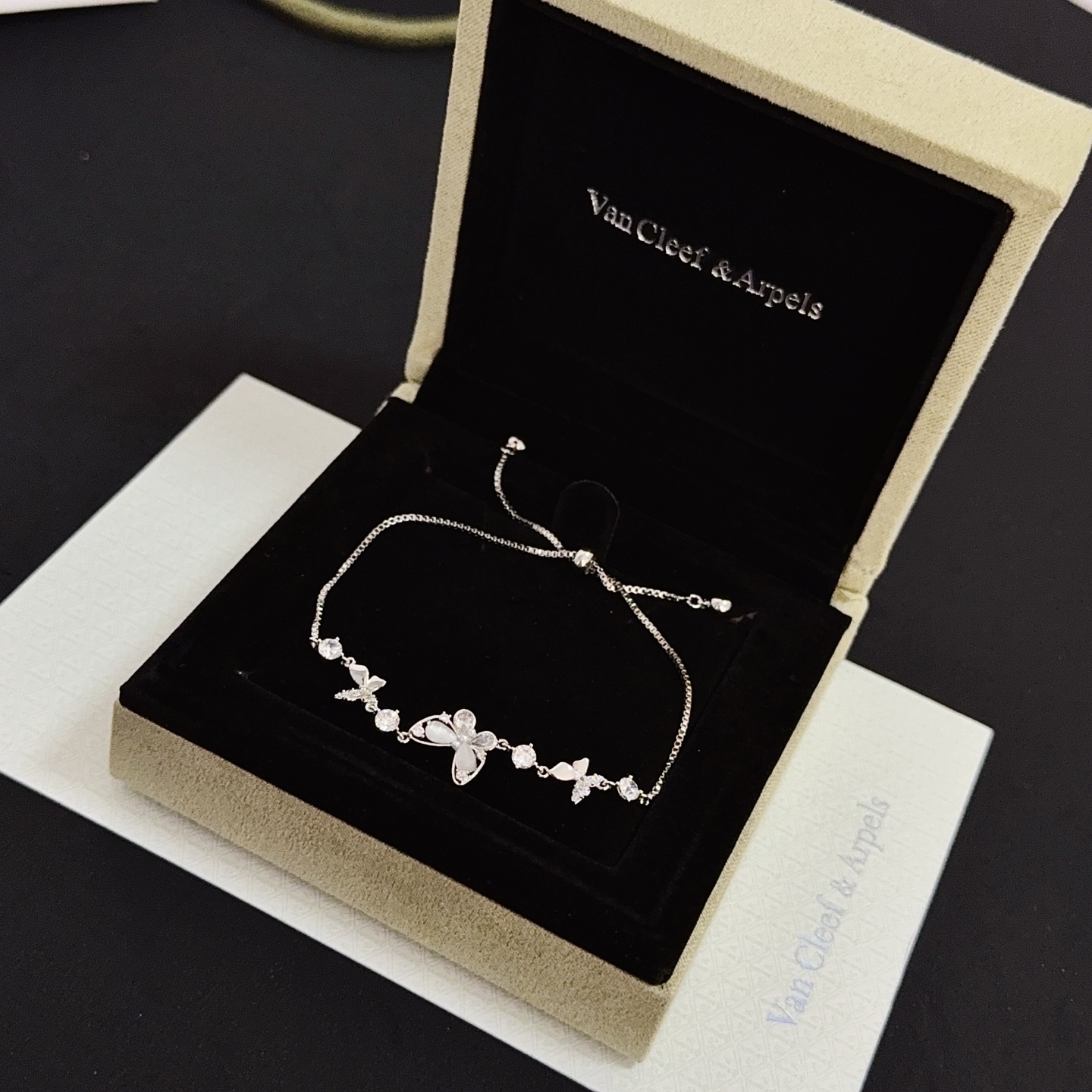 Bracciale regolabile Van Cleef Arpels con motivo a farfalla intarsiato con diamanti Metallo in oro bianco color argento con accenti di diamanti chiari e intarsi a farfalla in madreperla Chiusura scorrevole regolabile per polsi da 15-20 cm