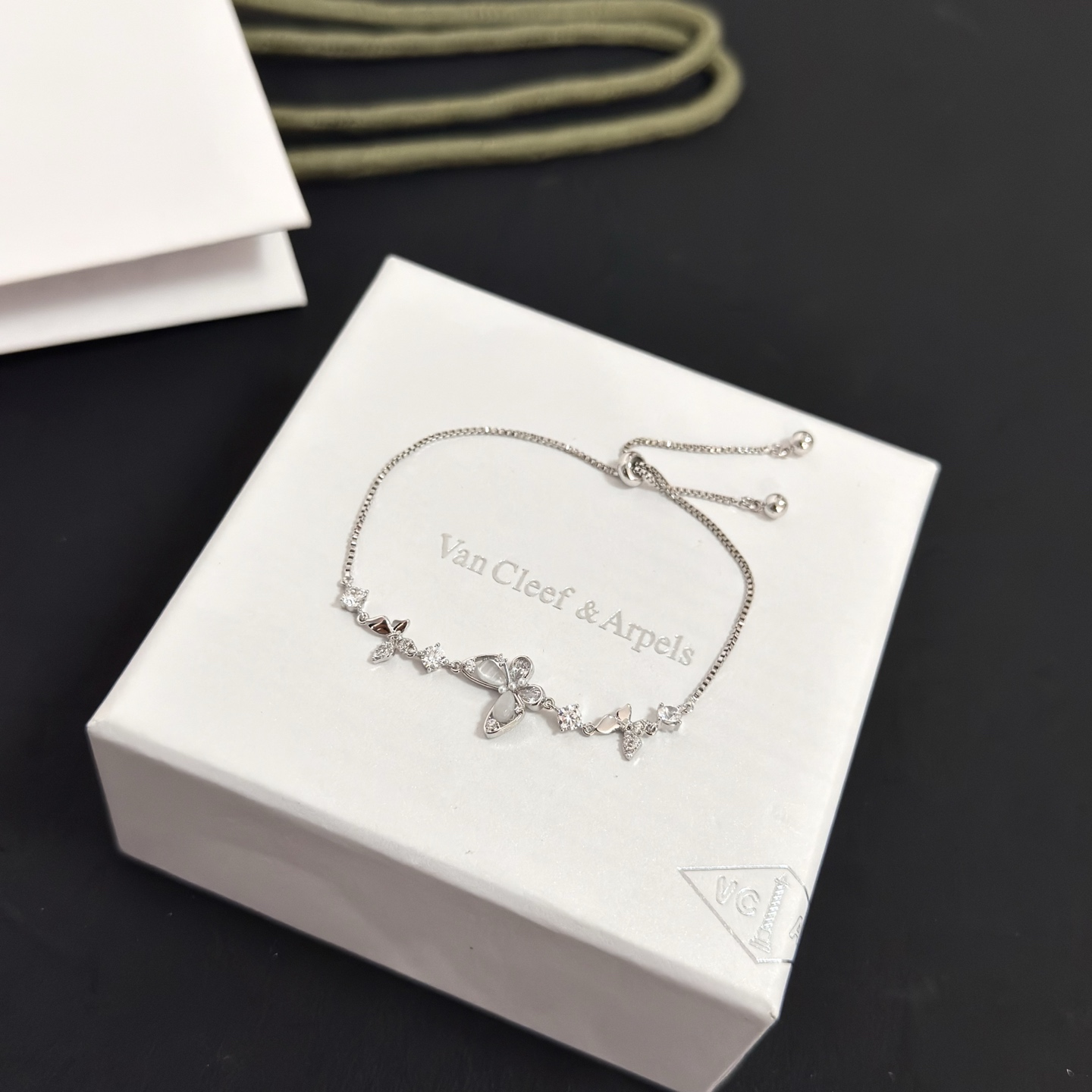 Bracciale regolabile Van Cleef Arpels con motivo a farfalla intarsiato con diamanti Metallo in oro bianco color argento con accenti di diamanti chiari e intarsi a farfalla in madreperla Chiusura scorrevole regolabile per polsi da 15-20 cm