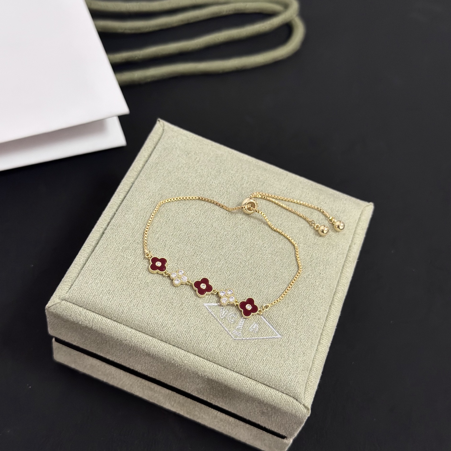 Van Cleef Arpels Alhambra bracelet yellow gold metal burgundy carnelian clover inlays clear diamond accents adjustable sliding chain maximum length 22cm