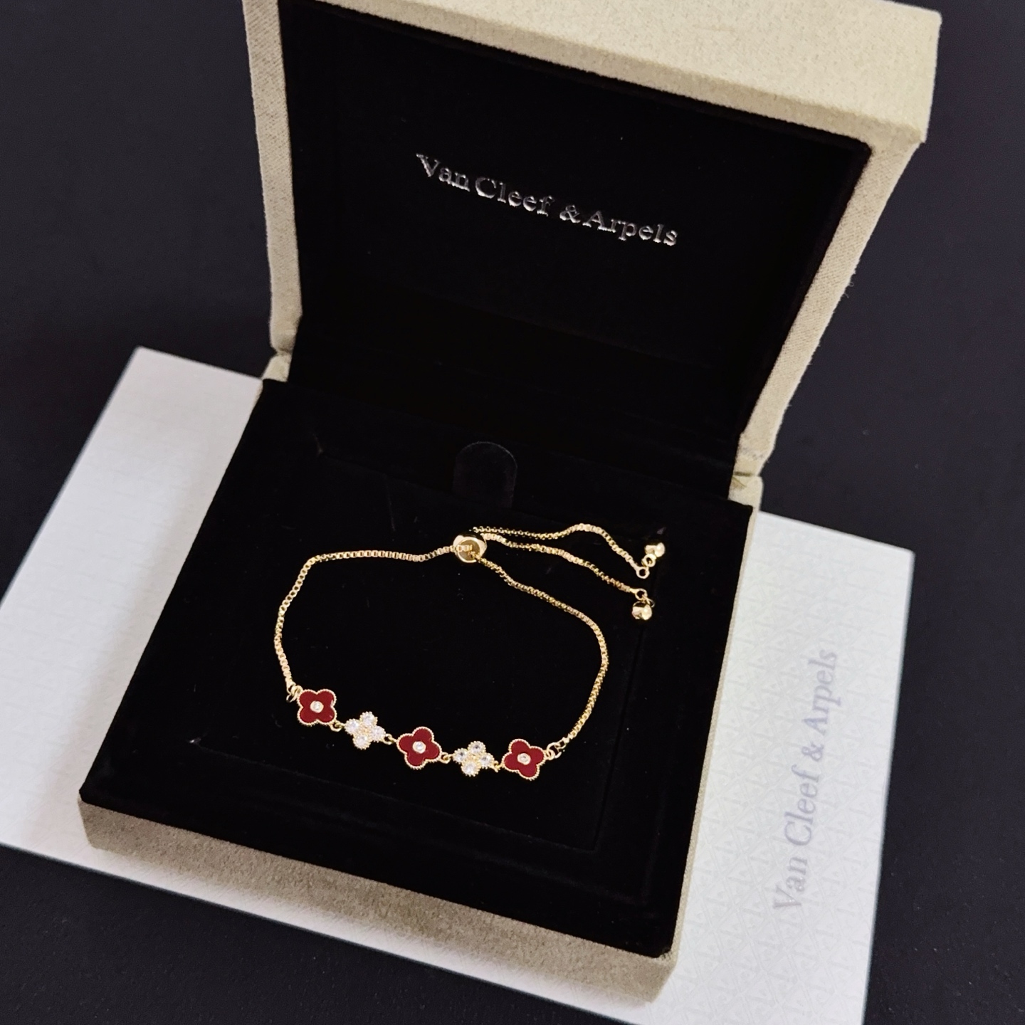 Van Cleef Arpels Alhambra bracelet yellow gold metal burgundy carnelian clover inlays clear diamond accents adjustable sliding chain maximum length 22cm