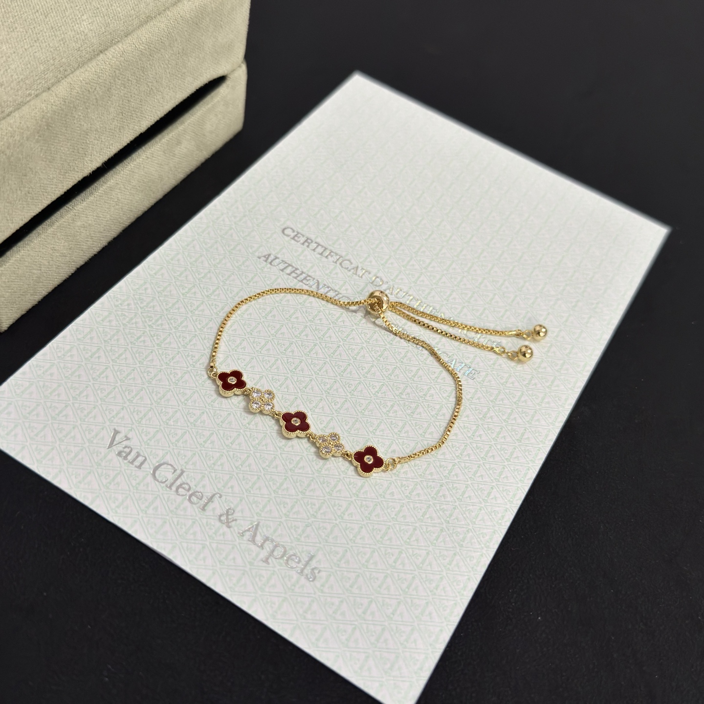 Van Cleef Arpels Alhambra bracelet yellow gold metal burgundy carnelian clover inlays clear diamond accents adjustable sliding chain maximum length 22cm