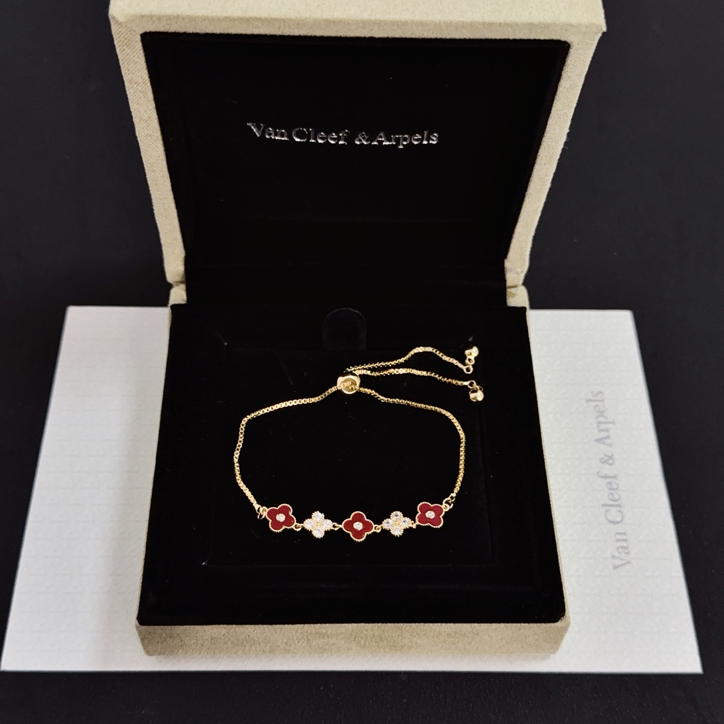 Van Cleef Arpels Alhambra bracelet yellow gold metal burgundy carnelian clover inlays clear diamond accents adjustable sliding chain maximum length 22cm