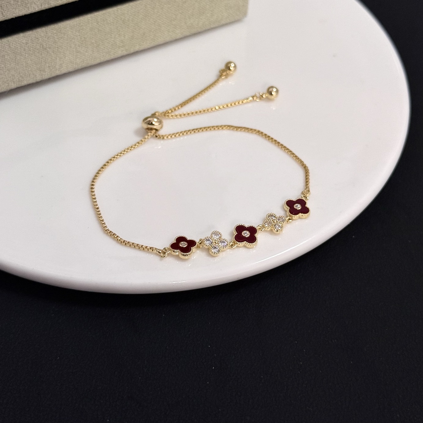 Van Cleef Arpels Alhambra bracelet yellow gold metal burgundy carnelian clover inlays clear diamond accents adjustable sliding chain maximum length 22cm