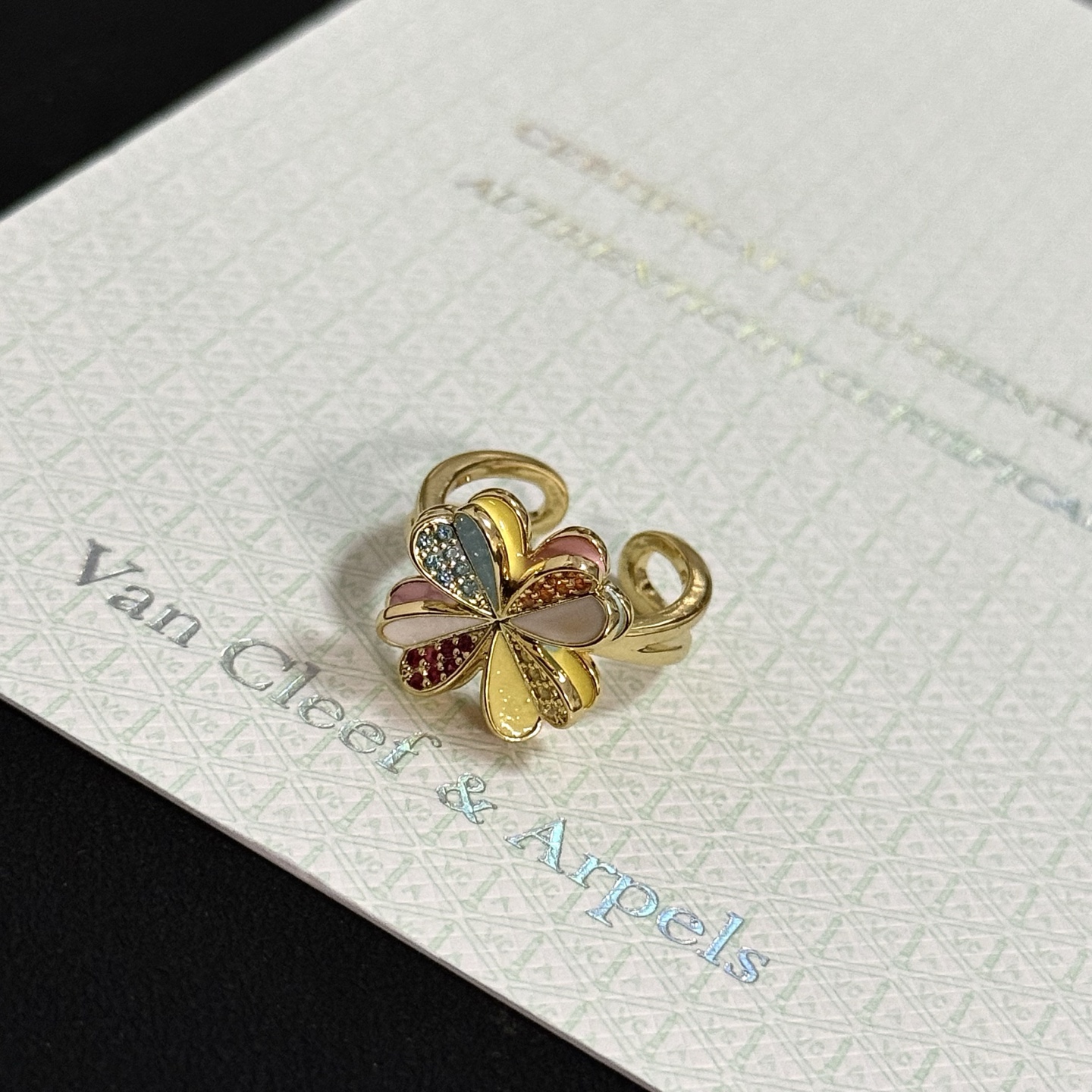 Anello Van Cleef Arpels Alhambra Four Leaf Clover in metallo dorato giallo con smalto multicolor e pavé di pietre preziose rosse arancioni gialle fascia aperta regolabile