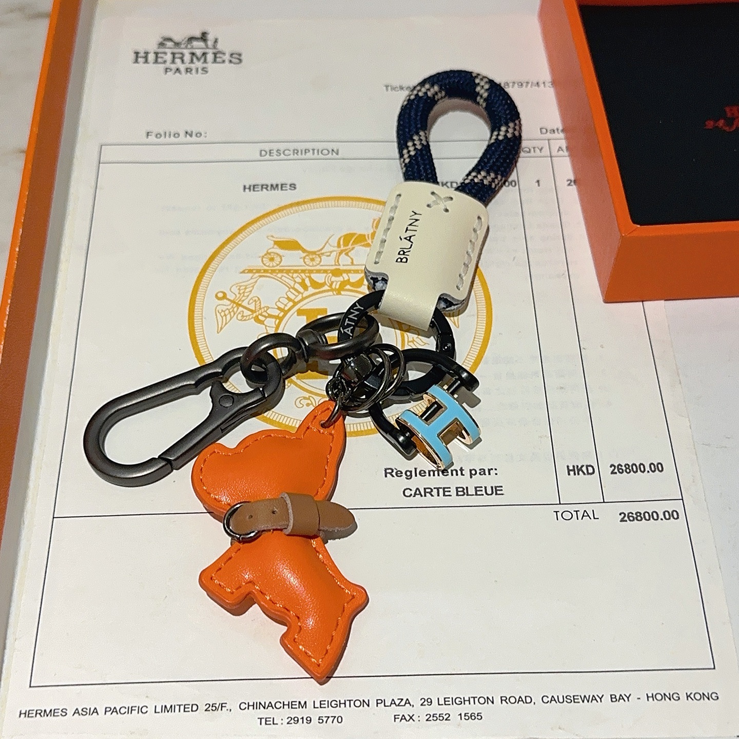 Hermes Pop H Dog Charm Portachiavi Ciondolo Hardware grigio canna di fucile Cavo intrecciato blu navy Accento in pelle color crema Ciondolo per cani in pelle arancione Dettaglio collare in pelle marrone Ciondolo H in smalto azzurro con finiture dorate Lunghezza totale 10 cm