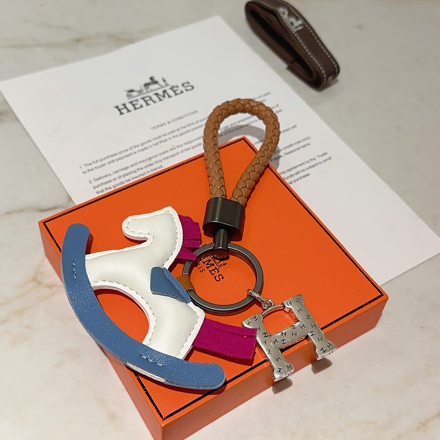 Hermes Rocking Horse H Charm Llavero colgante Correa de cuero trenzado marrón herrajes bronce de cañón Charm de caballo mecedora de cuero blanco azul fucsia Encanto de H en tono plateado 10 cm de longitud total