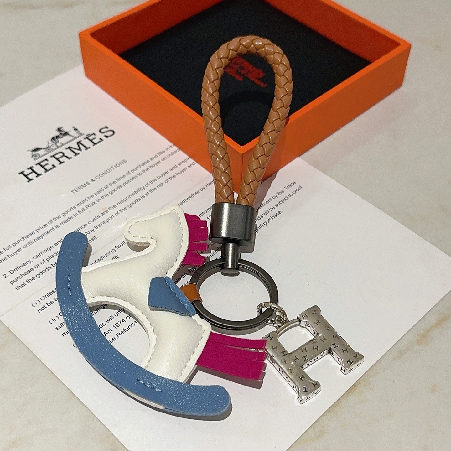 Hermes Rocking Horse H Charm Llavero colgante Correa de cuero trenzado marrón herrajes bronce de cañón Charm de caballo mecedora de cuero blanco azul fucsia Encanto de H en tono plateado 10 cm de longitud total